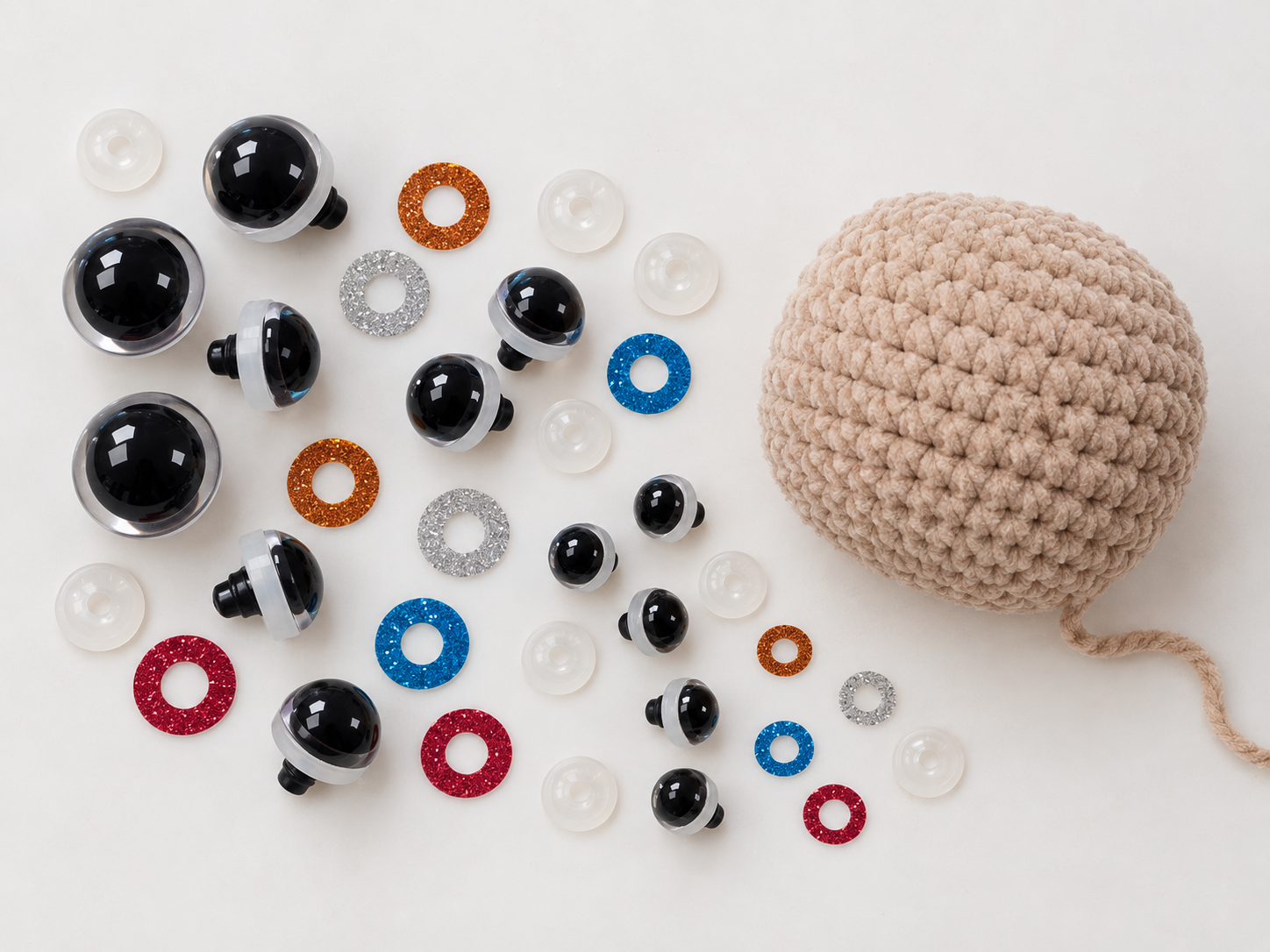 Amigurumi safety eyes with glitter washers next to a crocheted ball
